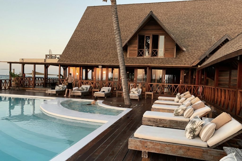 Boutique beachfront hotel with pool and loungers at sunset, the kind of independent property a hotel channel manager helps keep booked across OTAs