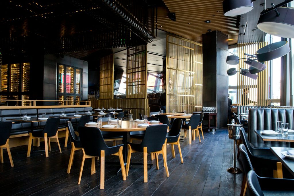 Restaurant dining room with empty set tables, the kind a reservation system like OpenTable or Resy helps fill