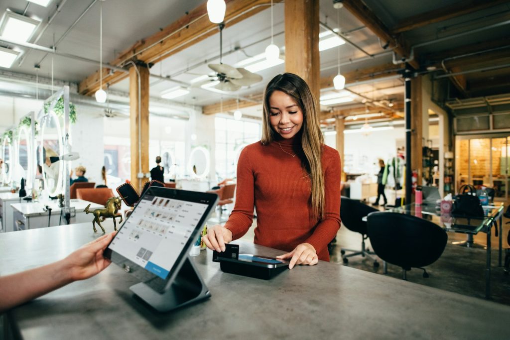 Restaurant staff using a POS tablet at the counter, comparing Toast vs Square for restaurants