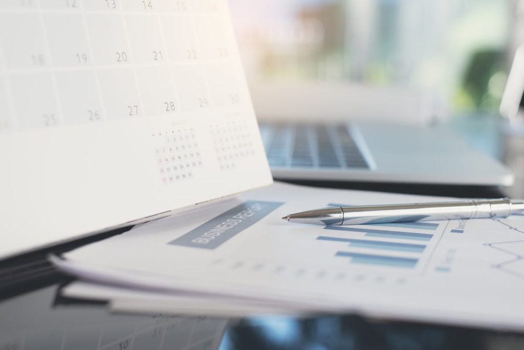 Vacation rental revenue management: desk with calendar, laptop and booking documents