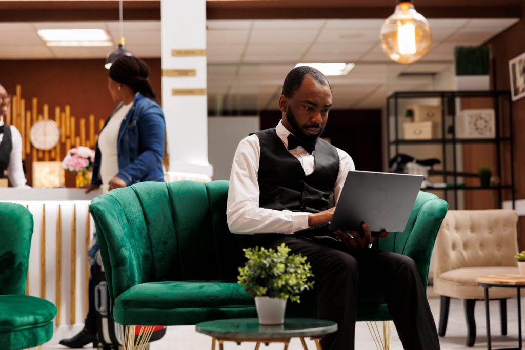 boutique hotel marketing: hotel manager reviewing direct bookings on a laptop in the lobby