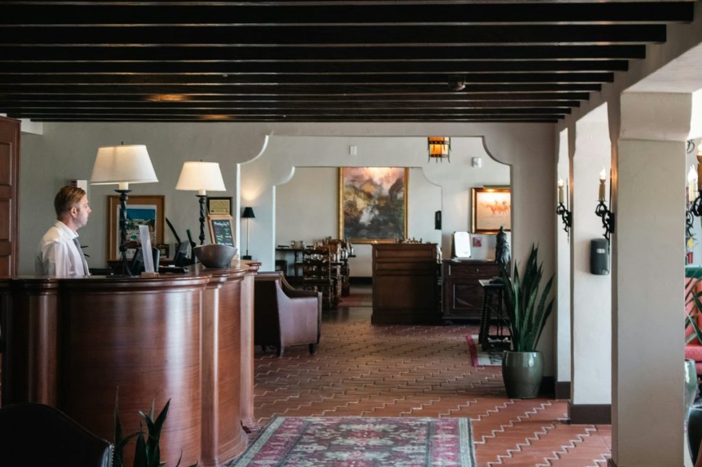 AI chatbot for hotels: a small hotel front desk with a staff member checking the computer
