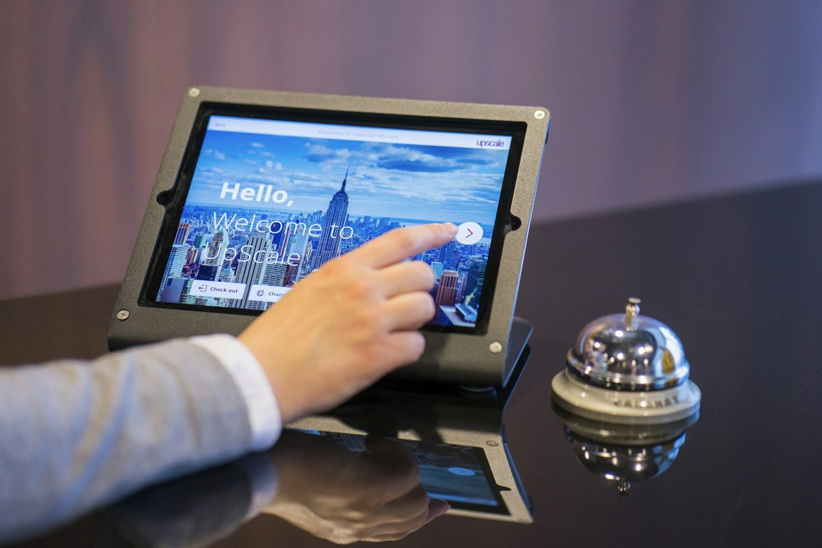 AI in hospitality industry: a guest using a tablet check-in at a hotel front desk
