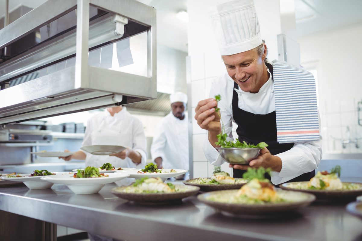 Chef plating dishes at the pass, part of how to increase restaurant revenue with a tighter menu