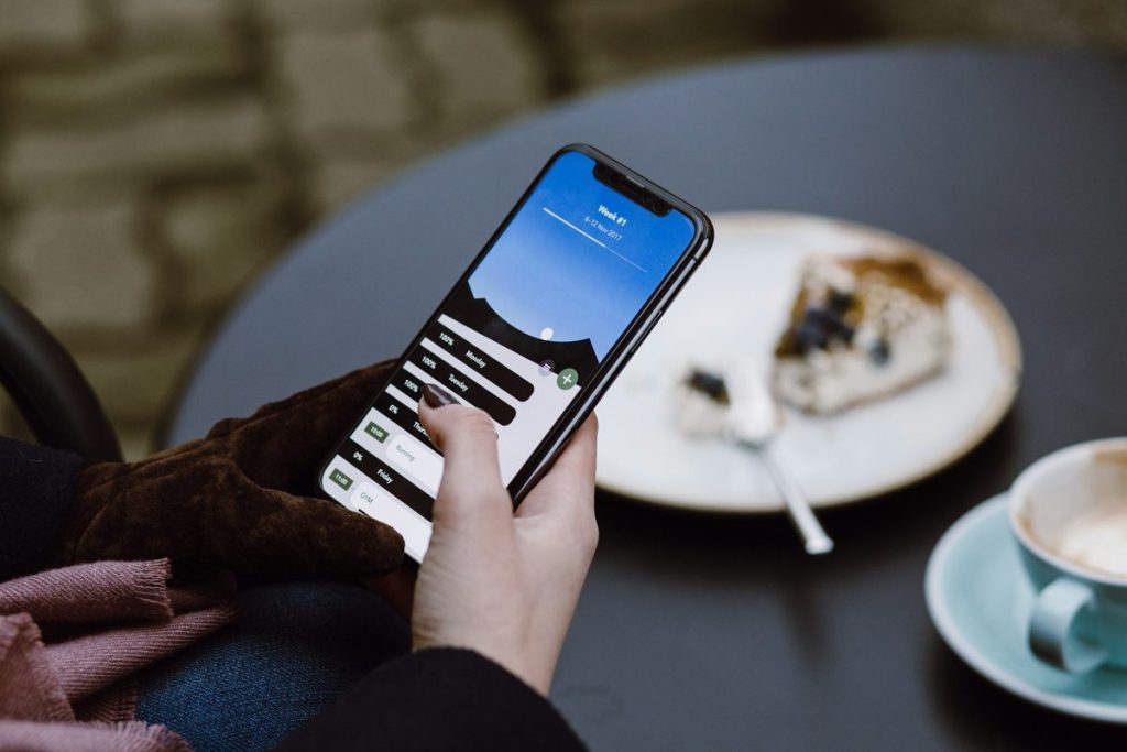 How to show up in ChatGPT: a guest searching on a phone at a cafe table