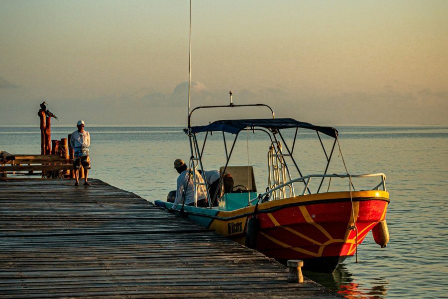 Boat at a wooden pier, part of Puerto Morelos marketing for tours and charters